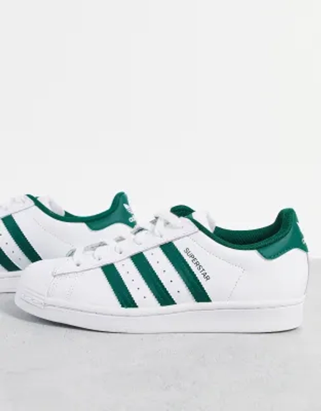 adidas Originals Superstar sneakers in white with collegiate green stripes | ASOS