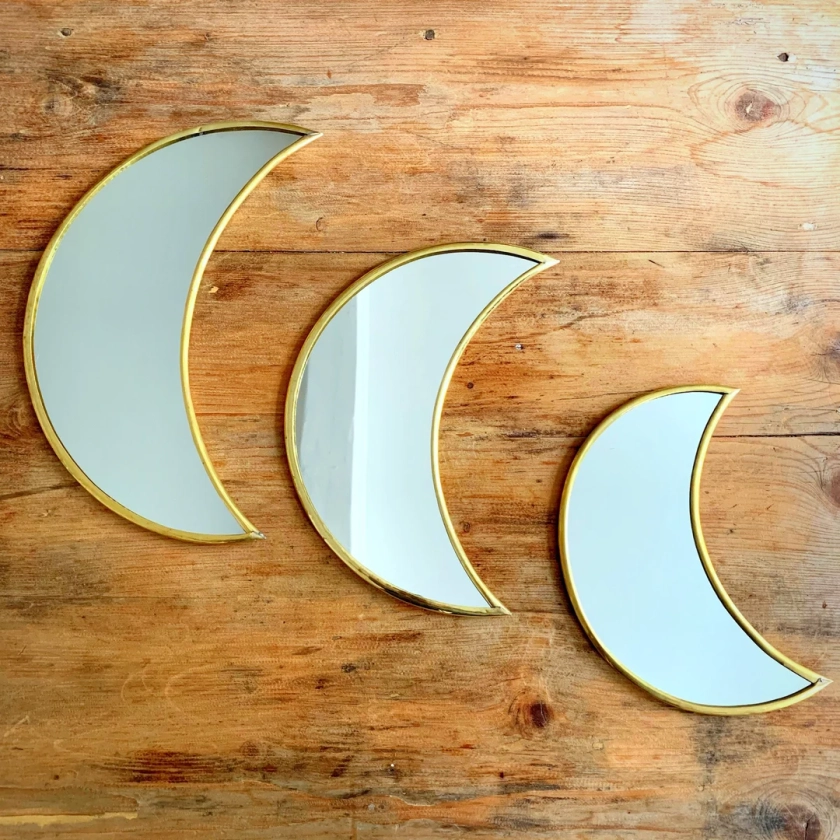 Golden brass wall mirror in the shape of a Moon