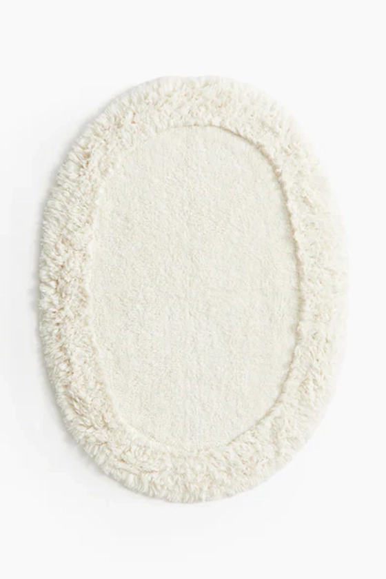 Oval tufted bath mat