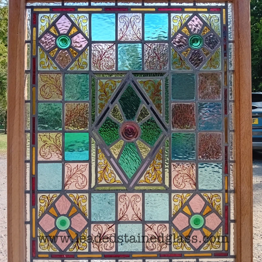 A1674. Hand painted floral panes within a geometric pattern window